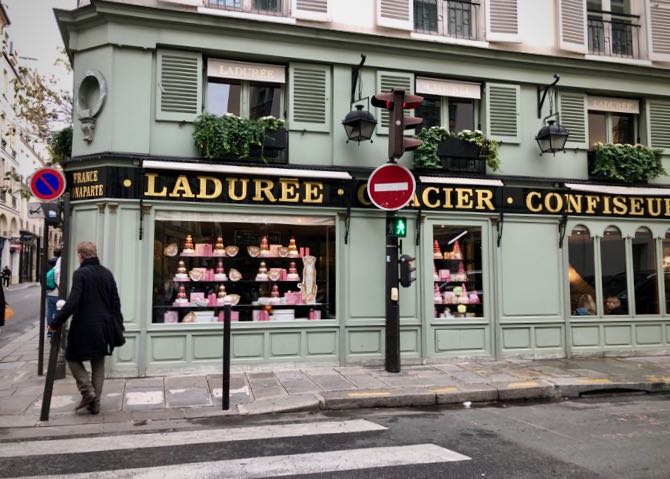 Mint-green exterior of a pastry shop in Paris, with towers of sweets in the window