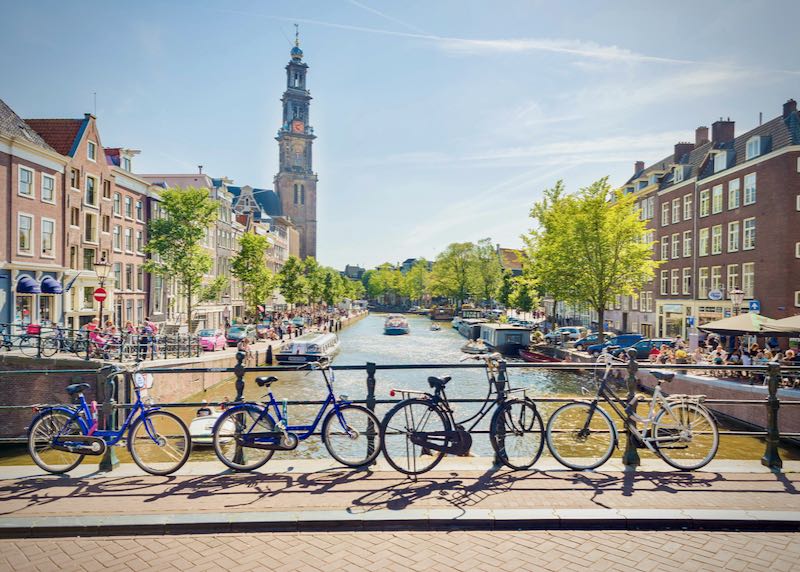 A view over one of the many canals in Amsterdam, with bicycles in the foreground.