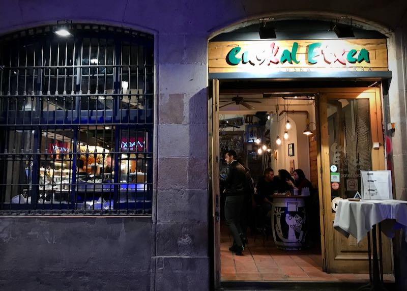 Exterior of a tapas bar in a stone building at night