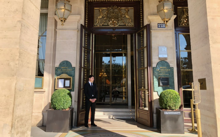 Doorman standing next to the door of a luxury hotel