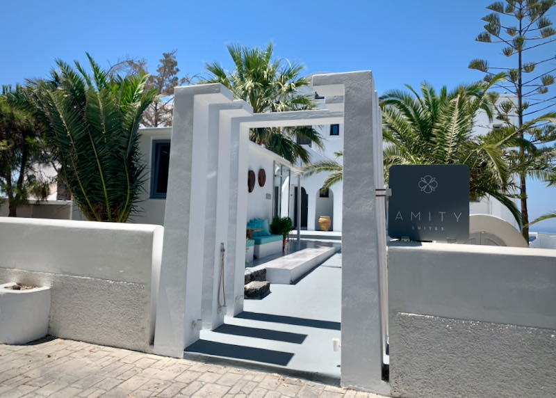 The white archway entrance to Amity Suites hotel in Santorini
