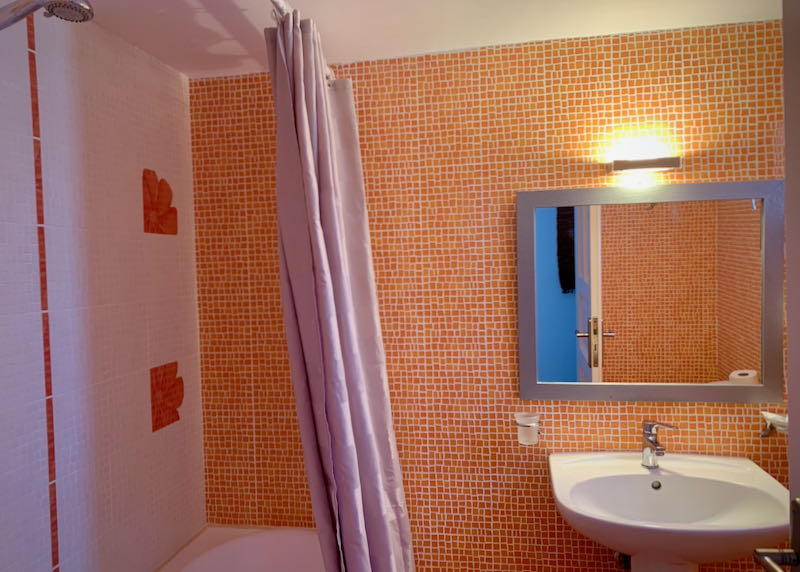 Orange-tiled bathroom with tub/shower combo