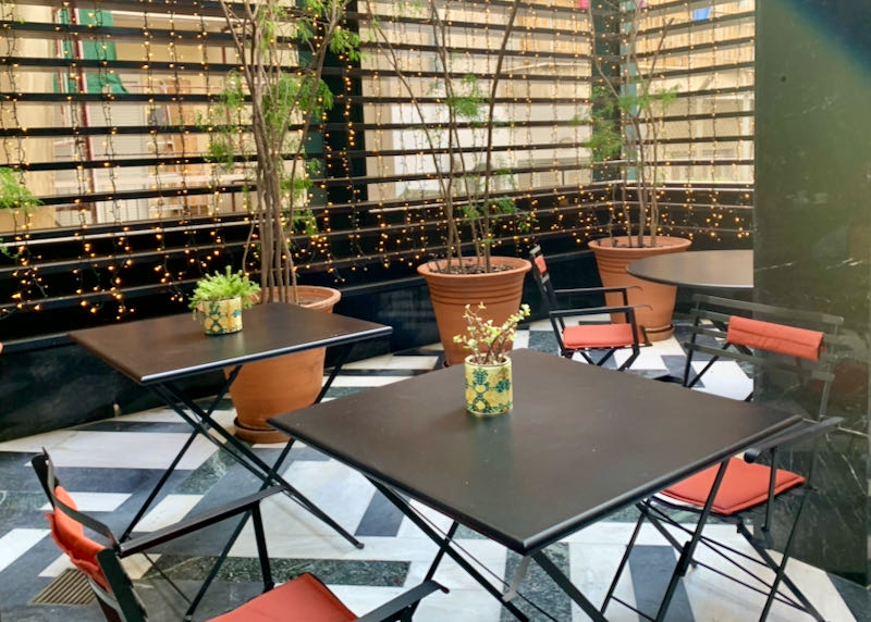 Cafe tables and chairs with potted plants