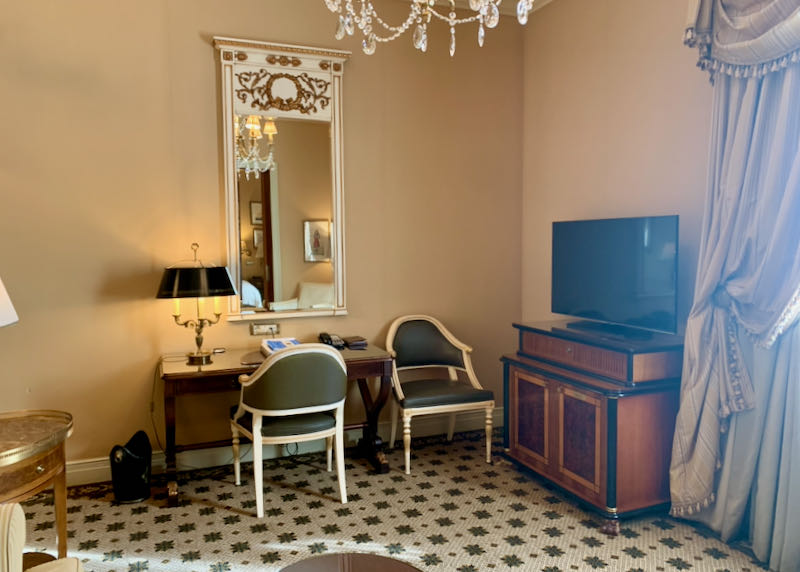 Hotel suite with a flat-screen TV and writing desk.