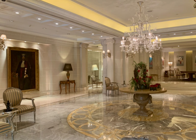 Wide marble hotel lobby with a fresh floral arrangement