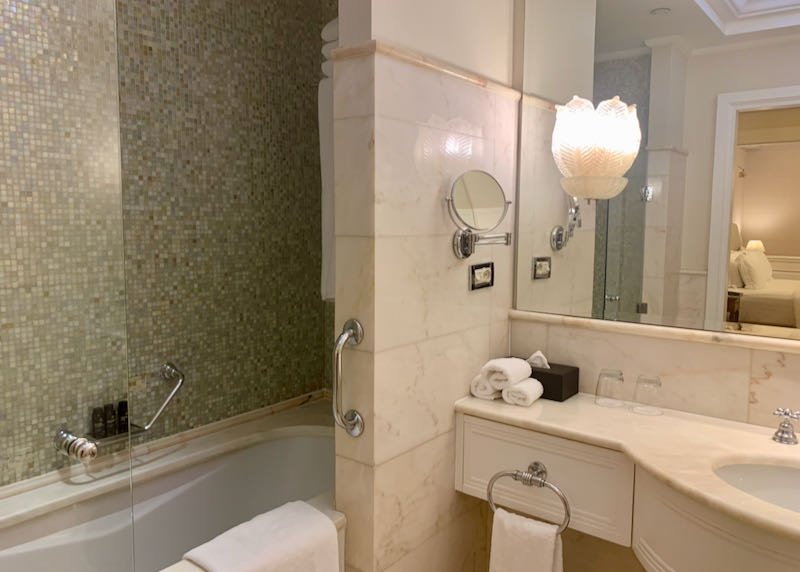 Marble hotel vanity and tub/shower with grab bars