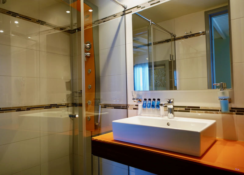 Hotel bathroom with glass shower and square basin sink