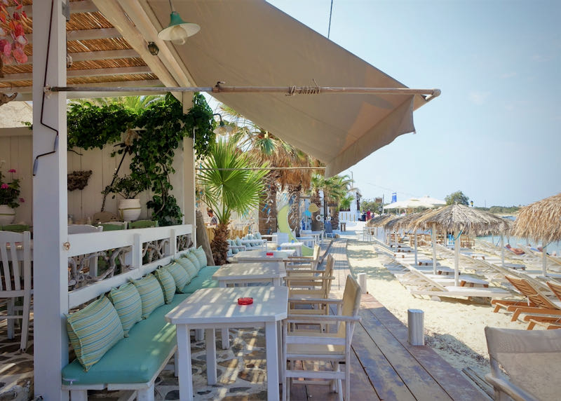 Tables set up on a boardwalk beside a sandy beach