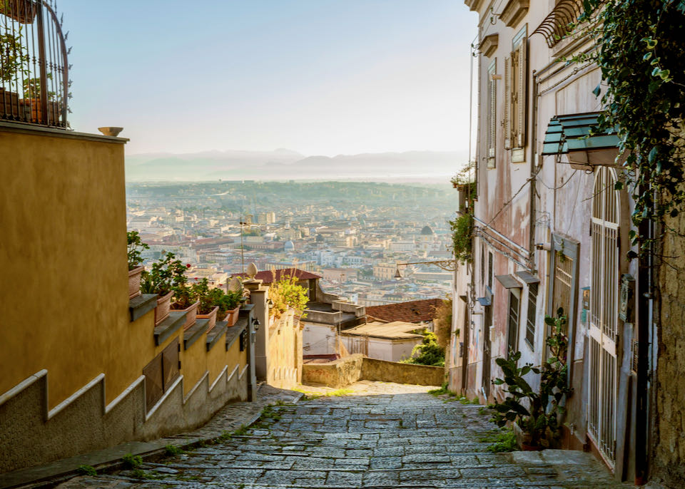 View of Naples from above, down an old cobbled lane lined with classical houses..