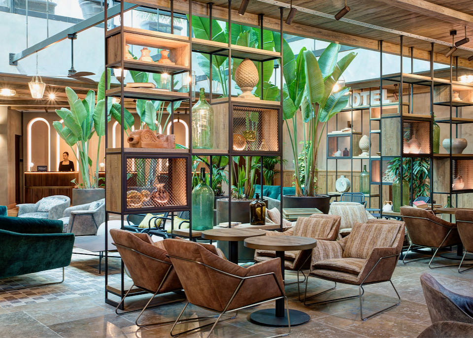 Hotel lobby with plants and modern industrial furniture and bookcases