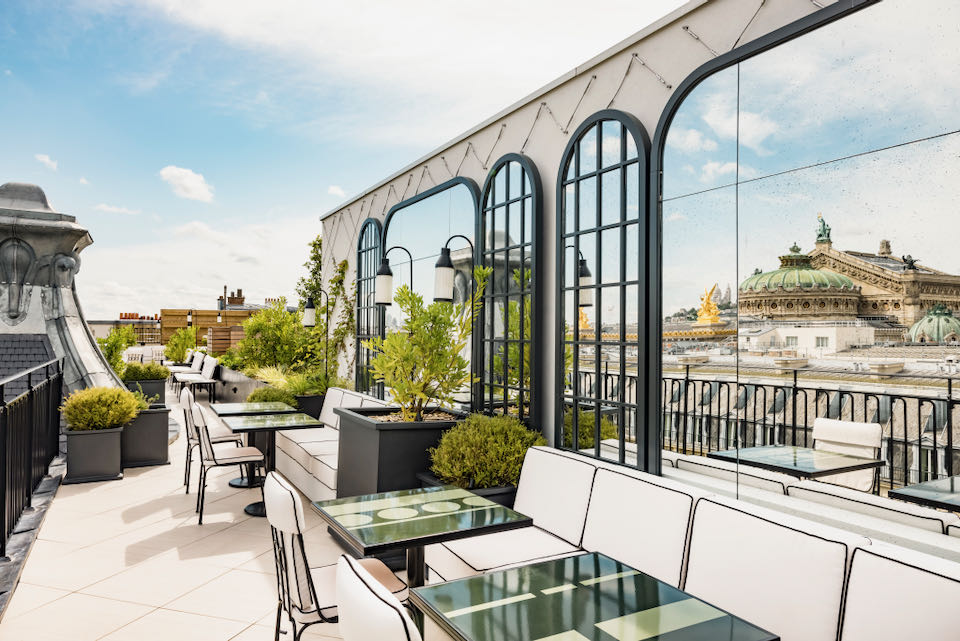 Paris rooftop with cafe tables, overlooking beautiful rooftops and iconic structures