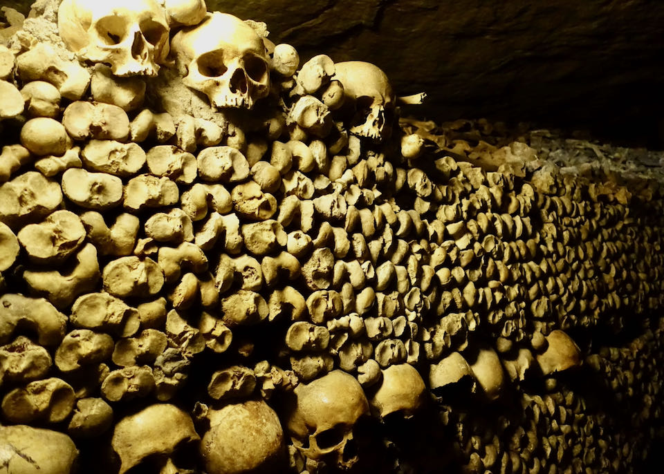 Human sculls and bones piled up in the Paris Catacombs.