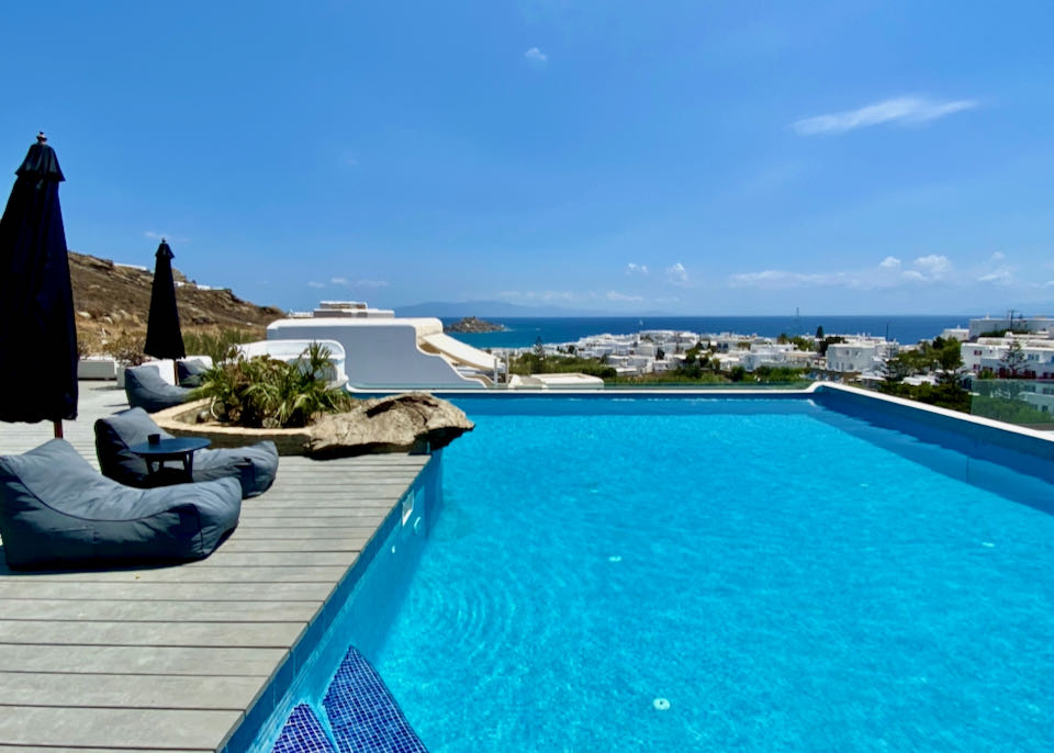 Pool deck with stuffed sun beds and a view of the sea