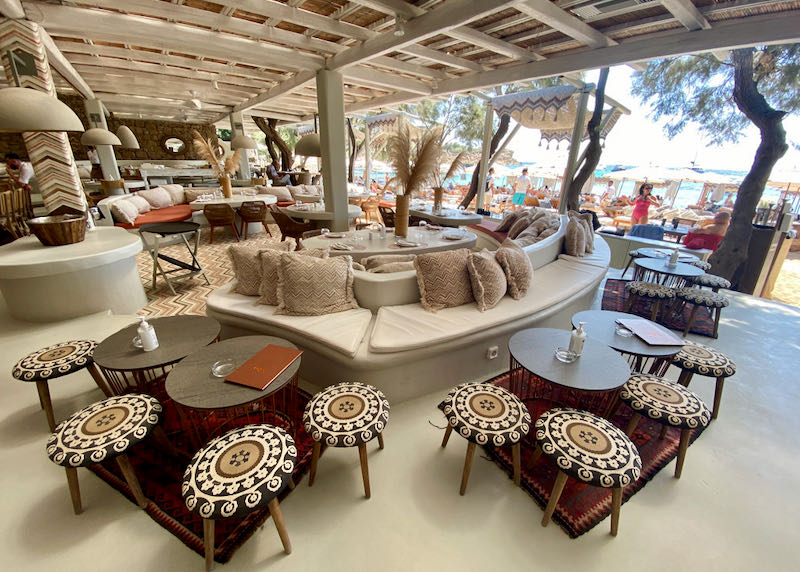 Stylish tables set up along a beach-front, open-air dining area