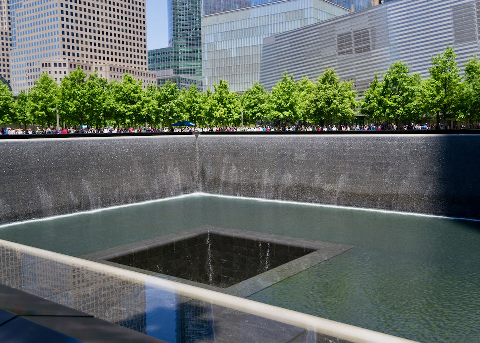 Tourists overlook the subterranean waterfall at the 9/11 memorial in New York