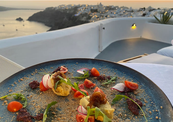 Appetizer plate set at a table with views of the Santorini Caldera