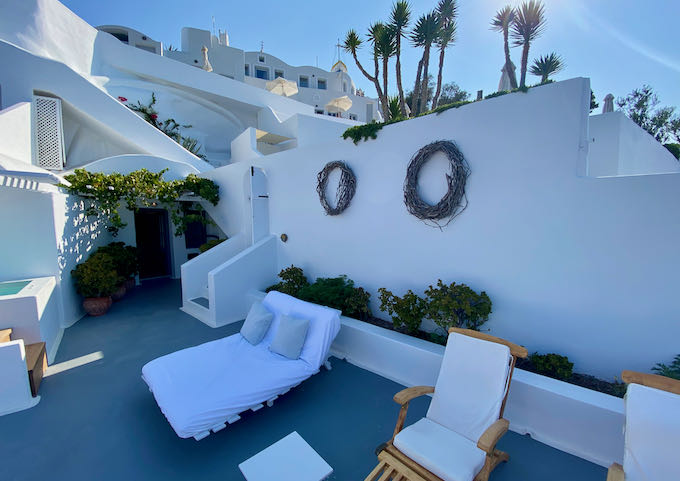 Whitewashed, Cycladic-style exterior walls, decorated with wreaths of grapevine