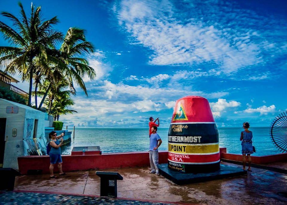 Tourists pose for a photo at a Key West landmark.