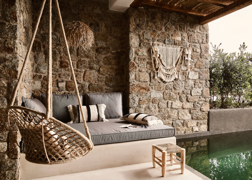  A built in outdoor sofa and swing chair next to a private plunge pool on a hotel balcony