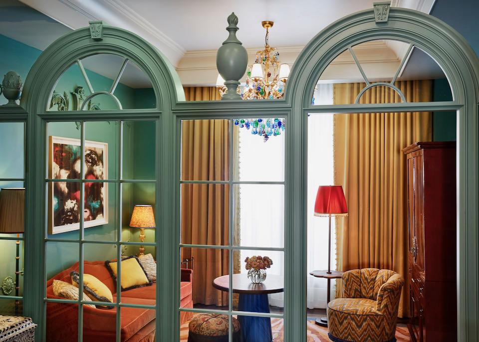 Beautiful lounge with antique furnishings, seen through teal-painted demi-lune windows