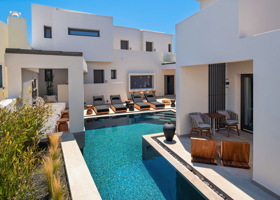 A sparkling blue swimming pool runs past guest suites and a sun terrace lined with loungers