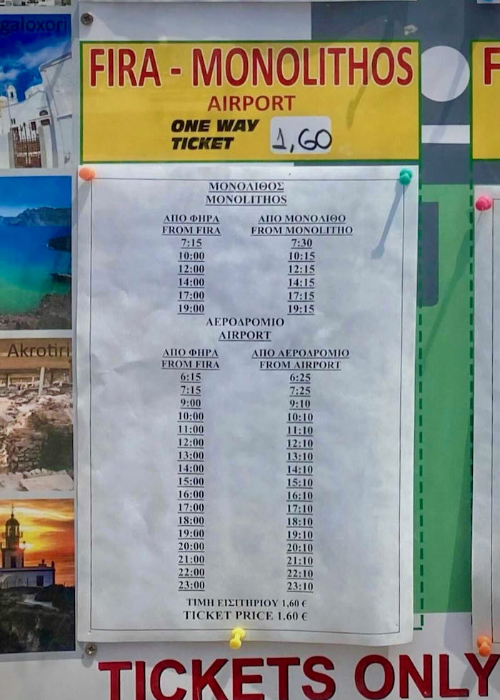A printed sign posted to a bulletin board shows the bus schedule to the Santorini Airport