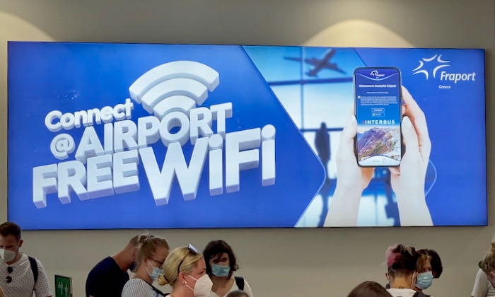 A brightly-lit sign advertising free wifi at the Santorini airport