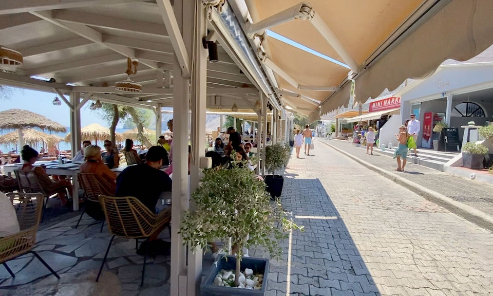 A paved path running alongside a string of beachfront restaurants.