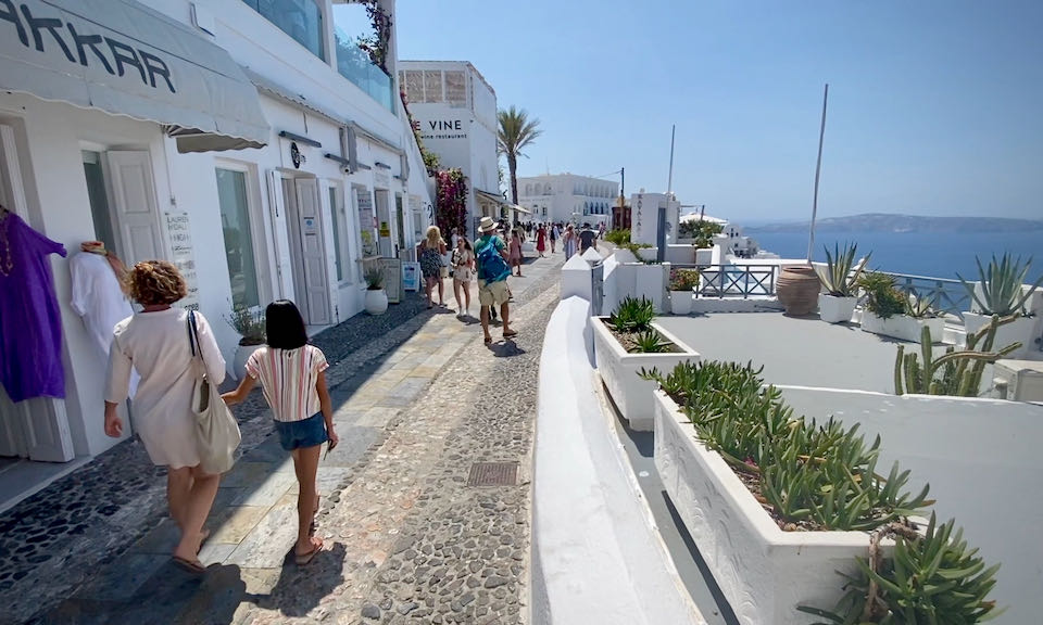 Pedestrians along a cobblestone footpath in Fira, Santorini
