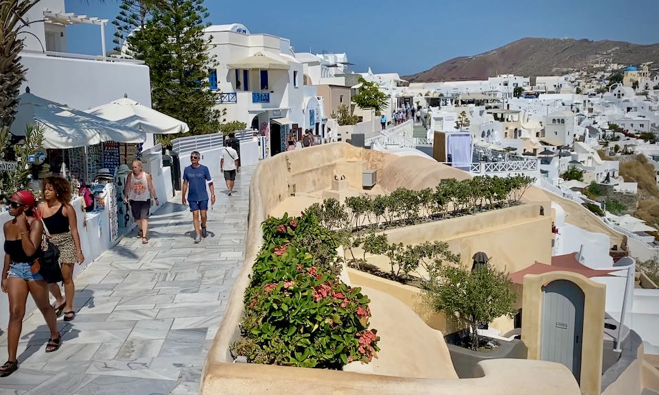 A marble footpath in a traditional Greek village, lined with shops.