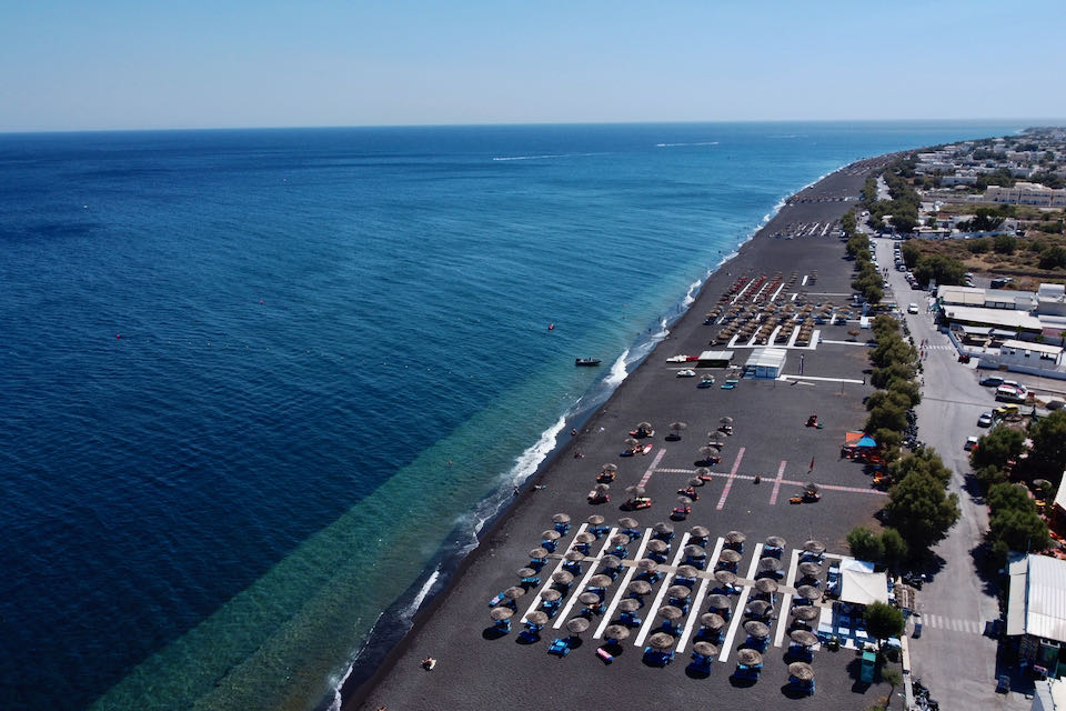 Aerial view of the black-sand Perissa Beach, showing the network of beach boardwalks. 