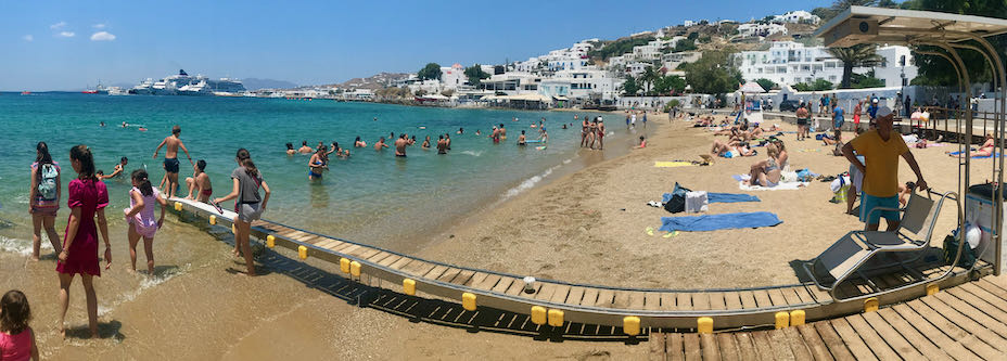 Panoramic view of children playing on a sea access ramp for disabled beachgoers.