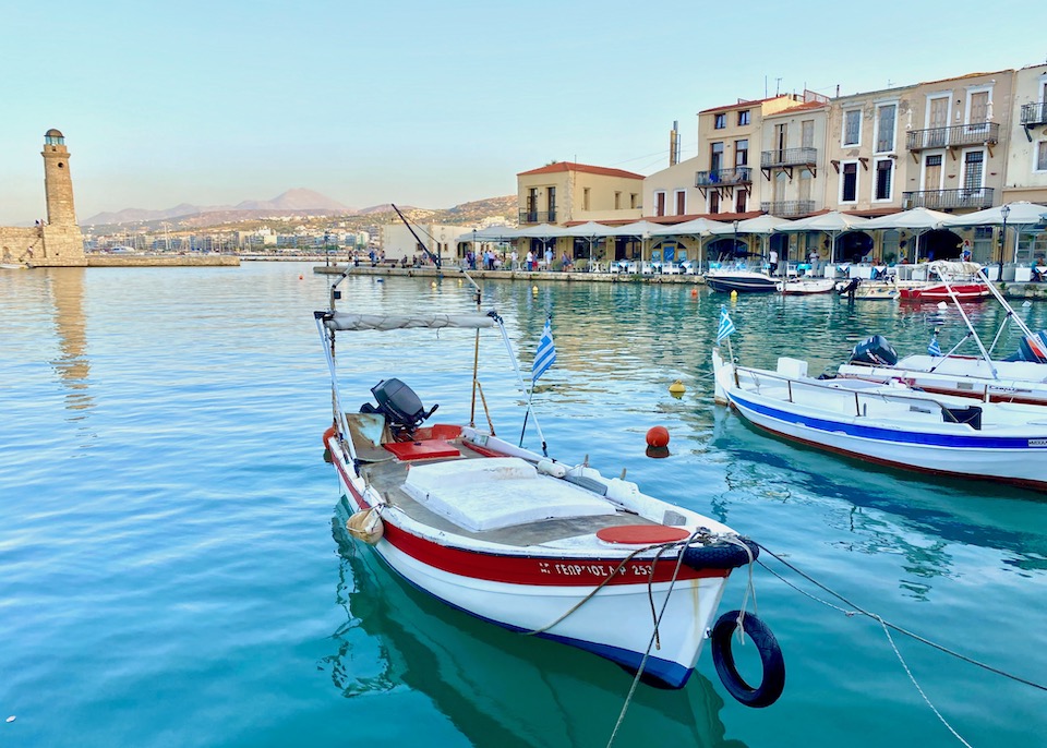 Afternoon on the harbor with restaurants and the lighthouse in Rethymno, Crete.