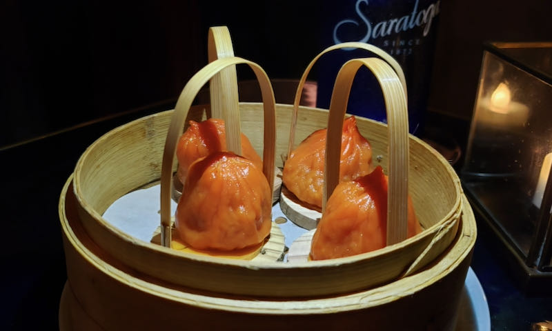 Four dumplings in a bento-style steam basket