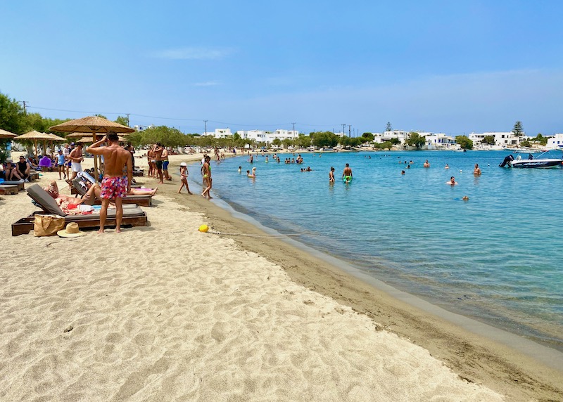 Busy Pollonia Beach with sunbeds and umbrellas in Milos