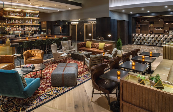 Hotel lobby with Oriental rug, leather couches, and bar seating