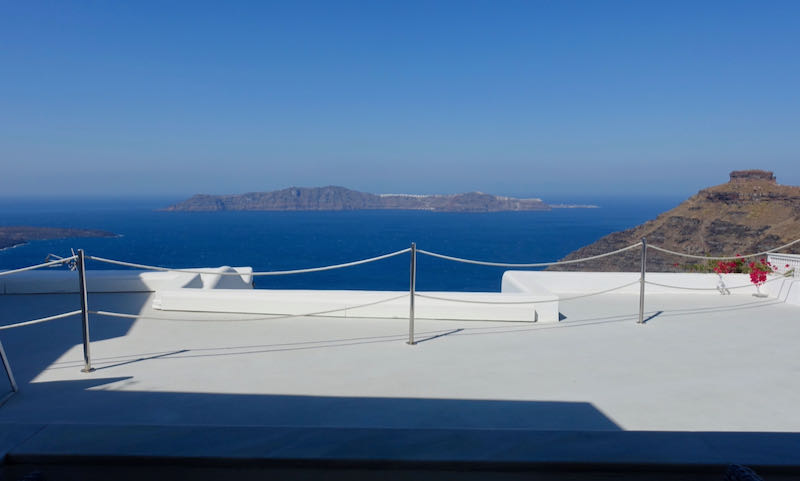 The blue Aegean Sea and Santorini Caldera from a whitewashed sun terrace.