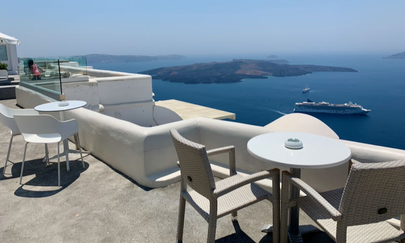 A cafe table overlooks the Santorini Caldera