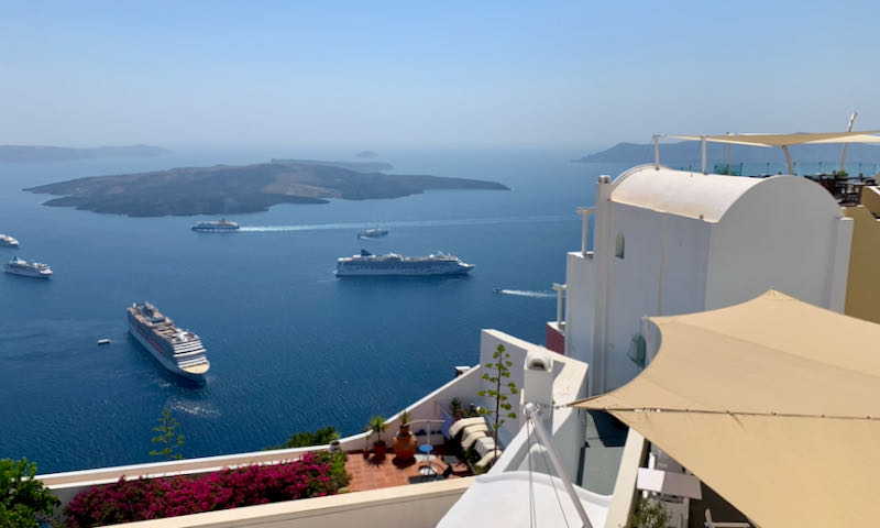 Cruise ships in the Santorini caldera, as seen from the deck of a cliffside hotel
