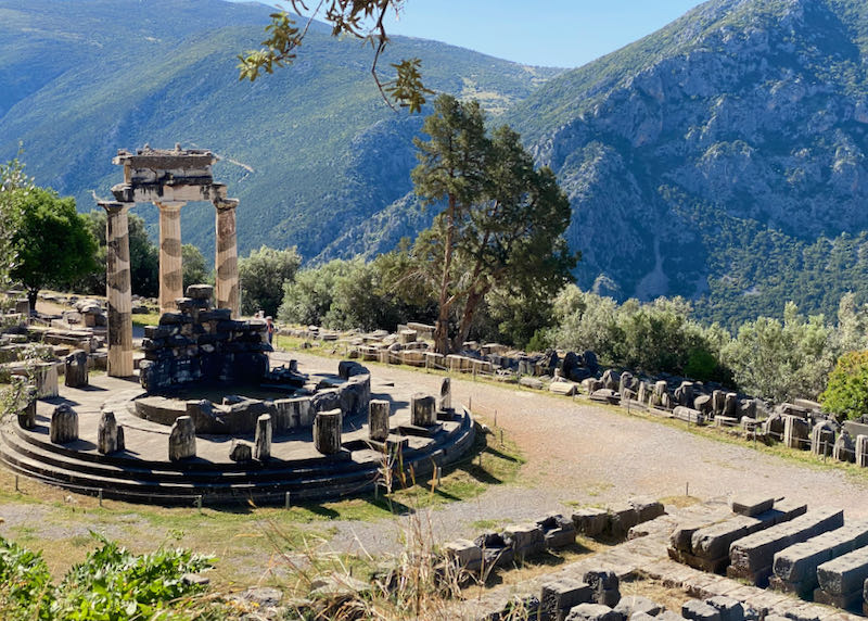 Stone ruins of an ancient circular temple on a green mountainside