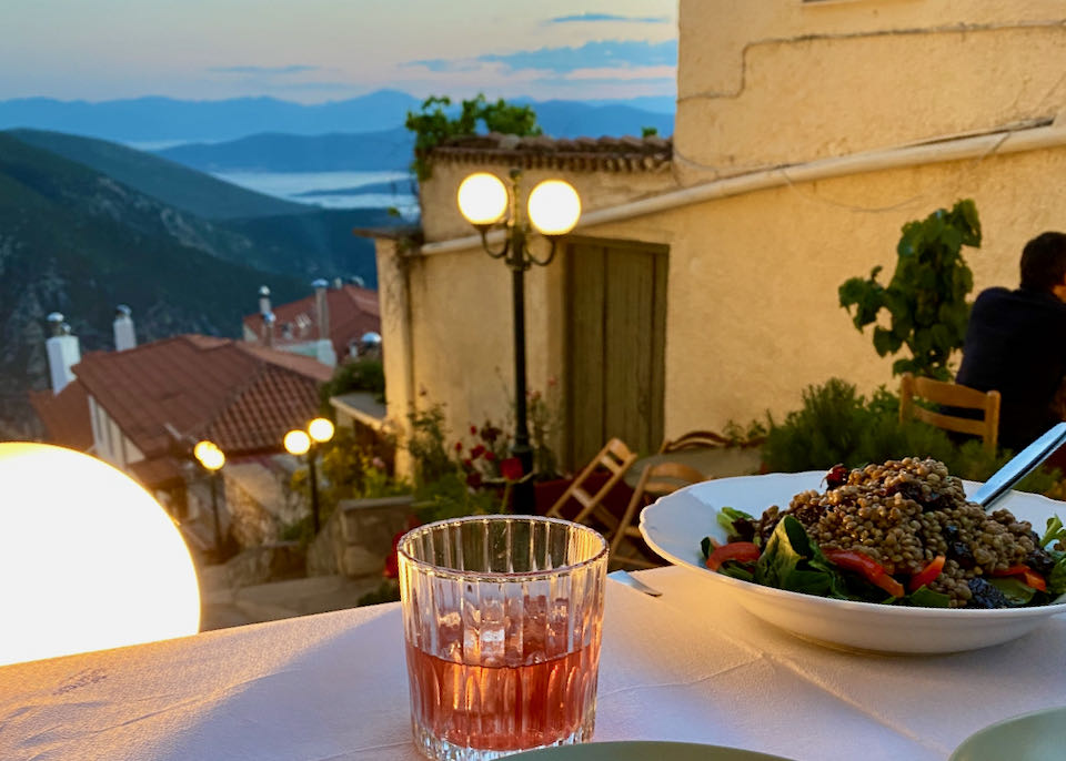 View looking over a table of food to the Corinthian Gulf at twilight