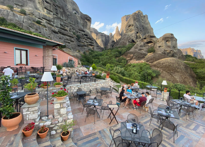 Diners at terraced seating against a backdrop of towering rock formations