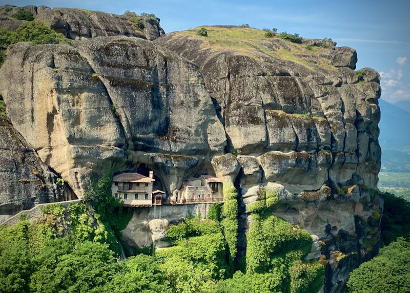 A stone monastery building built into the side of a cliff