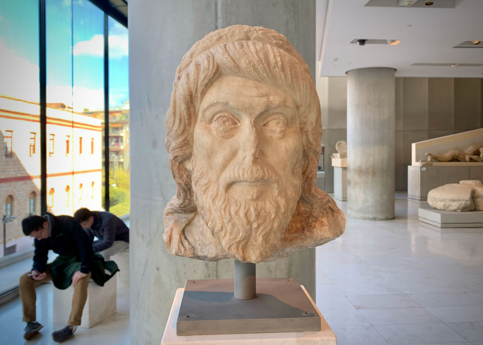 Sculpture of a man's bearded head on display in a museum gallery