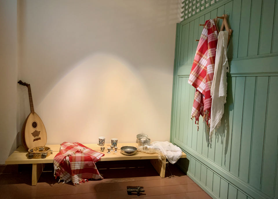 Wooden stall with musical instruments on a bench and towels hanging on wall pegs