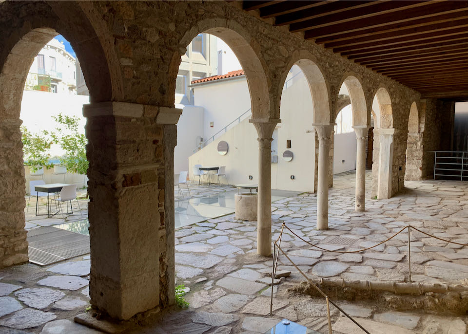 View of a stone courtyard through an arched passageway