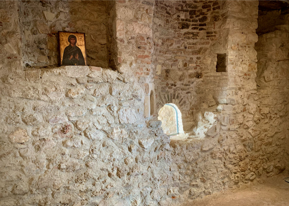Stone-built room with a small window and a saint's icon displayed