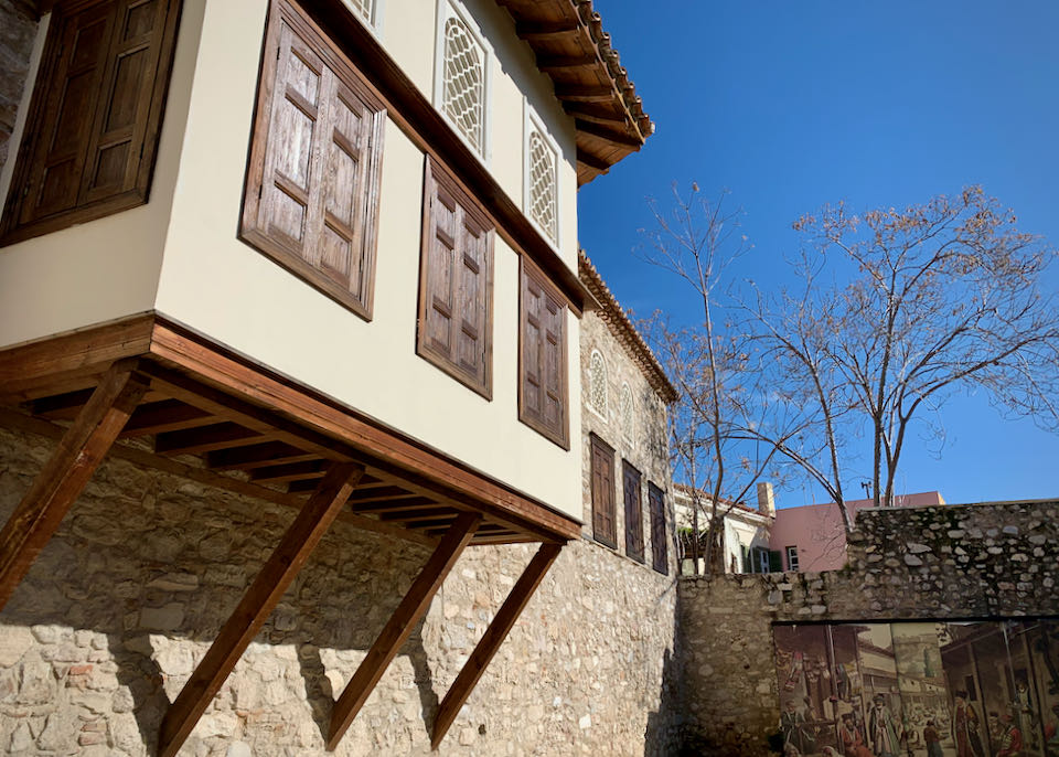 Exterior of an Ottoman-style home with a secon story jutting out over a stone base