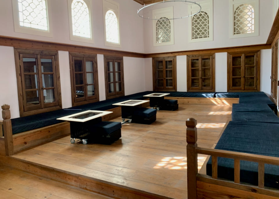 Large high-ceilinged room with built-in benches and arched windows