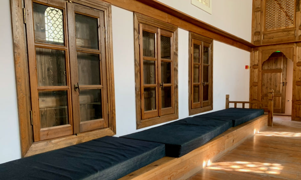 Carved wooden windows above a built-in wooden bench